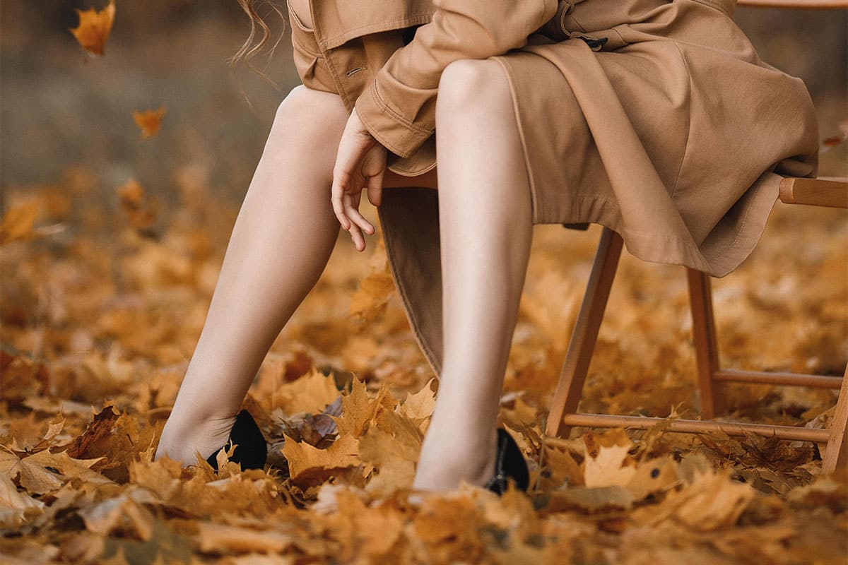 Frau mit glatten Beinen im Herbstlaub